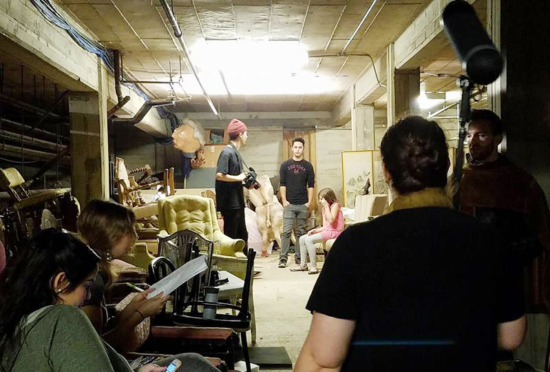 Photo of students shooting film scene in a basement